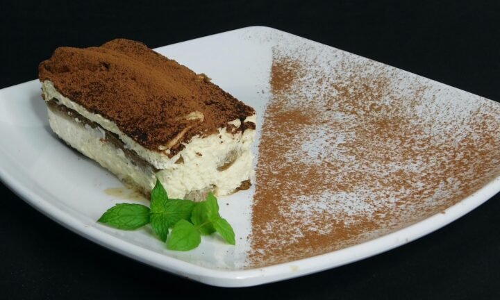 pedaço de tiramisu em um prato branco de cerâmica decorado